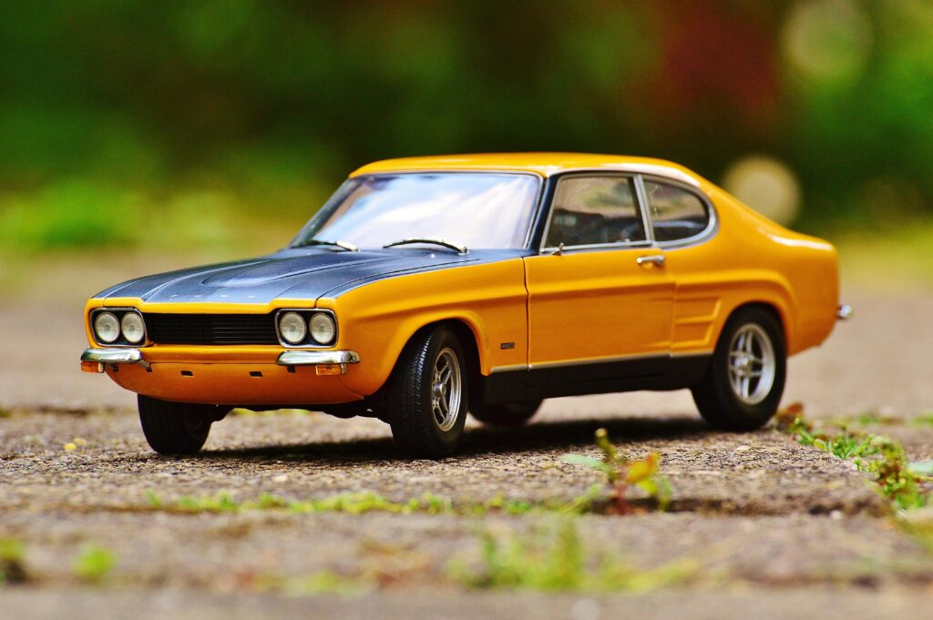 Detailed miniature Ford Capri model car with vibrant colors on an outdoor surface.