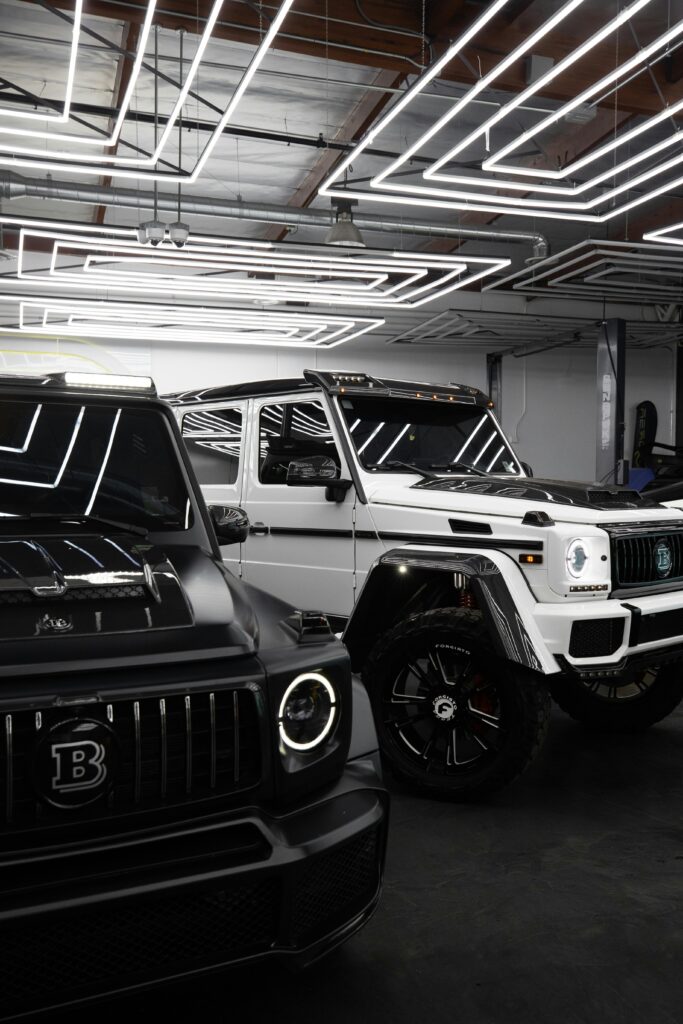 Luxury Mercedes Benz cars parked indoors with sleek lighting reflections.